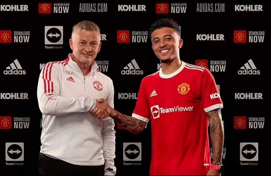 Jadon Sancho tươi cười bên cạnh HLV Ole Solskajer trong buổi ký hợp đồng với Quỷ Đỏ thành Manchester